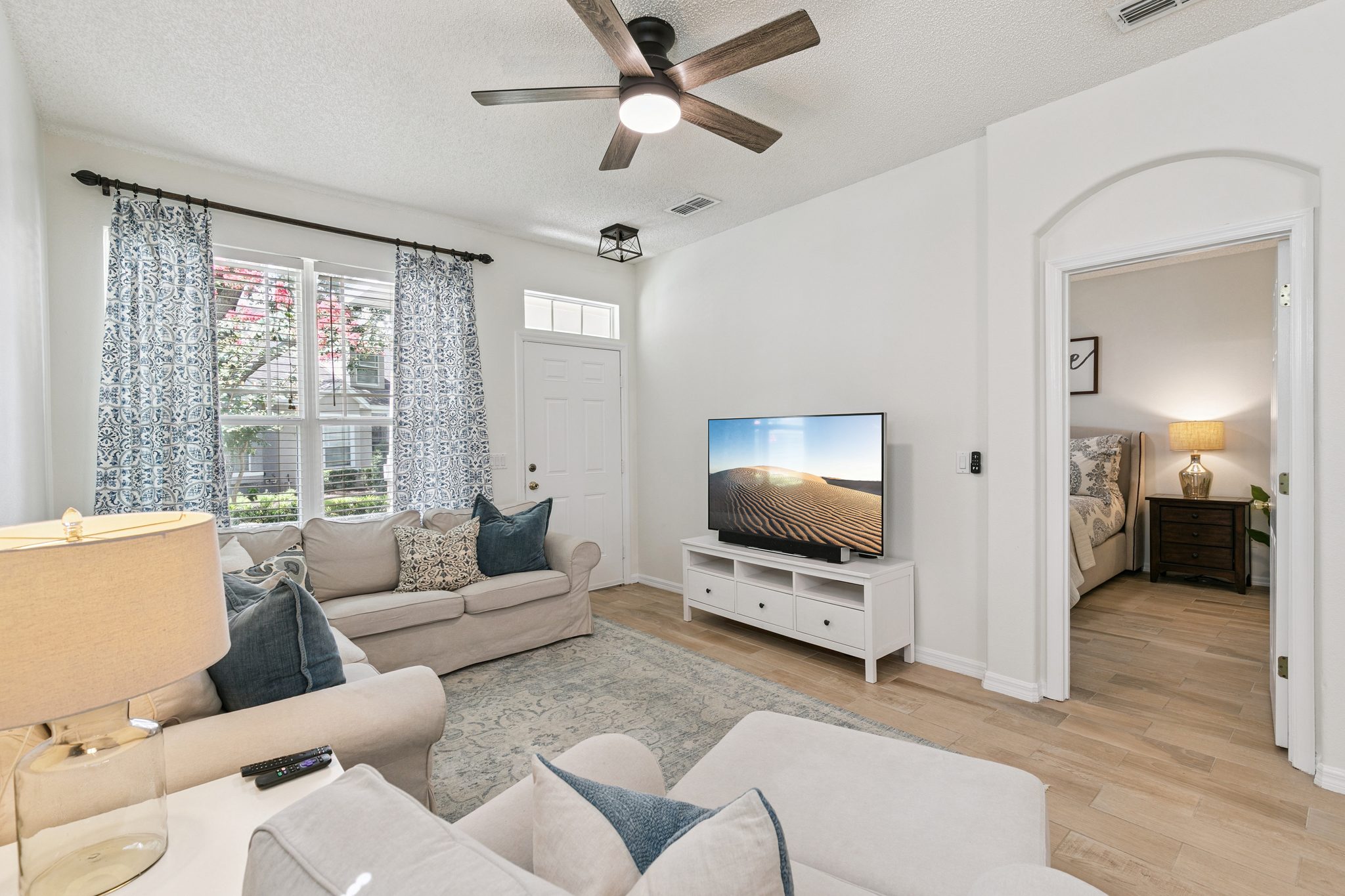 Open living room filled with natural light, with a sightline to the entry and hall at 13449 Carroway St, Windermere