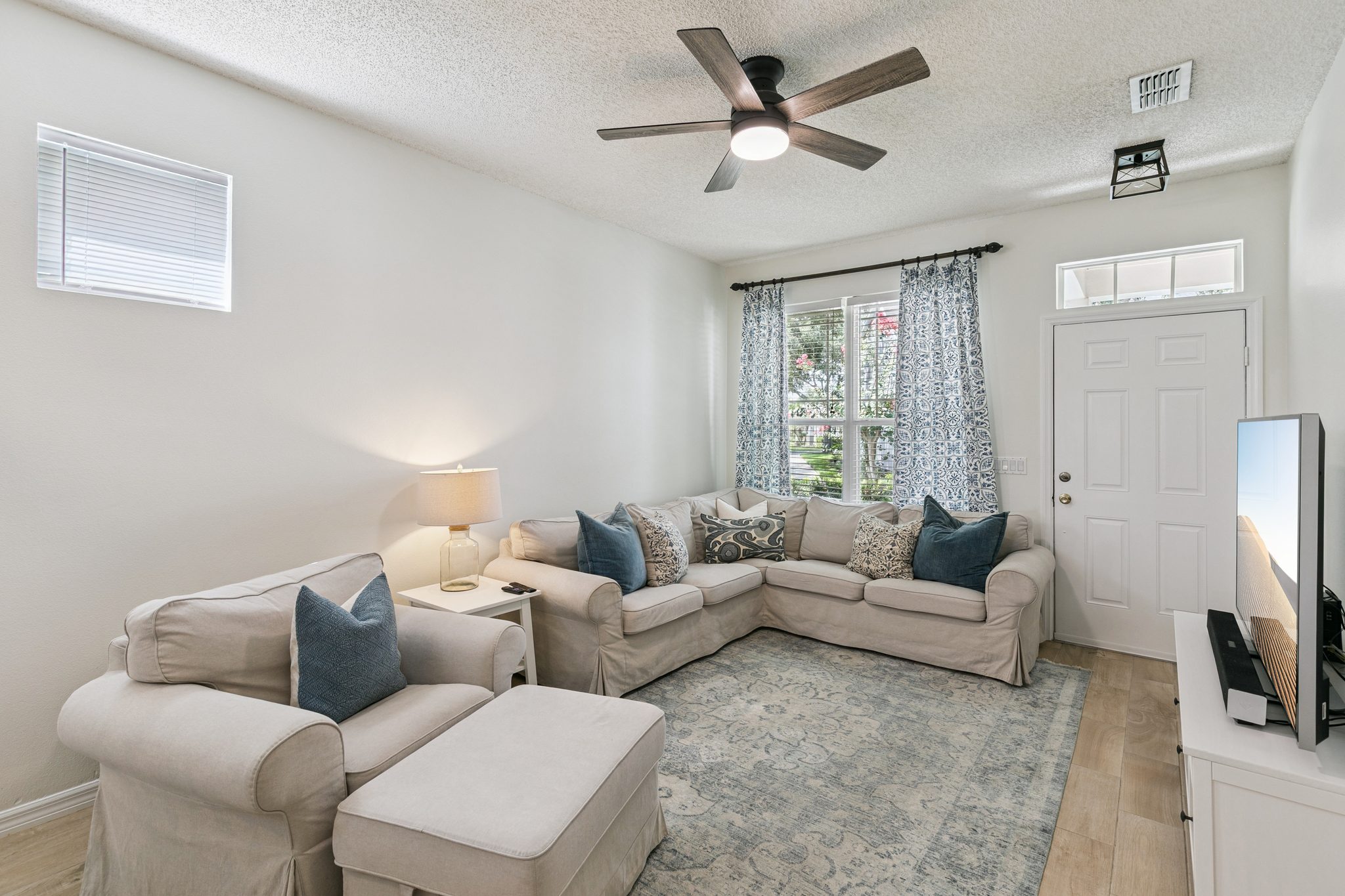 Living room with a sectional sofa and bright front windows at 13449 Carroway St, Windermere