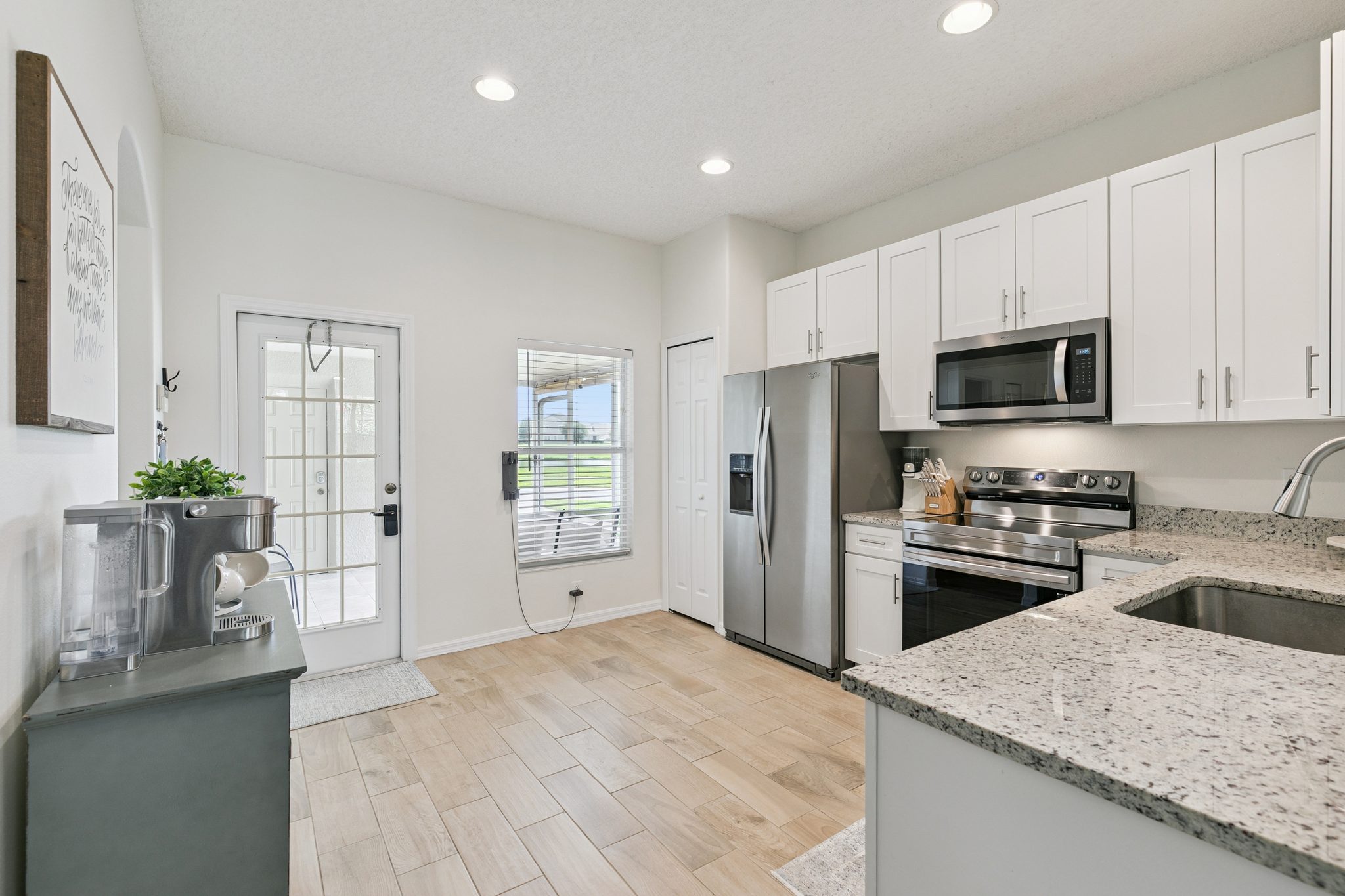 Kitchen with the full stainless appliance suite and access to the screened patio at 13449 Carroway St, Windermere