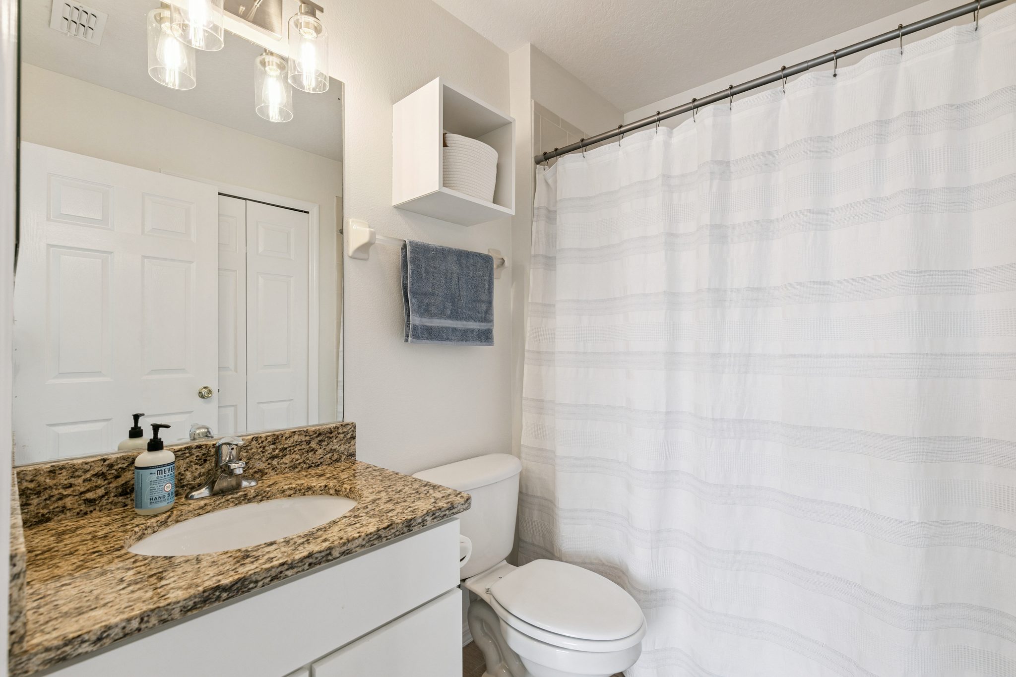Full bathroom with a shower-tub, granite-topped vanity, and modern fixtures at 13449 Carroway St, Windermere